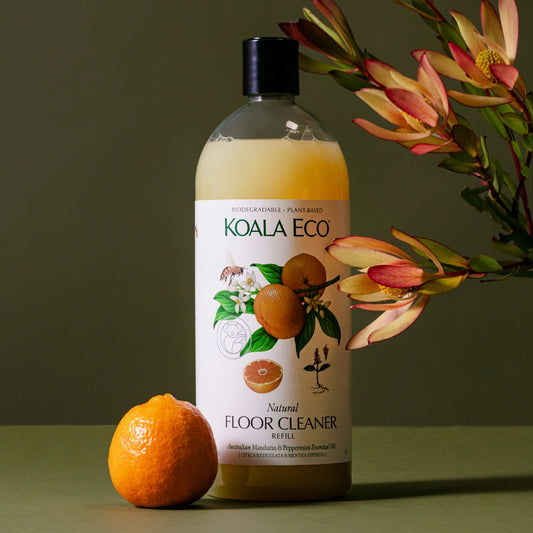 Koala Eco natural floor cleaner refill bottle with an orange and flowers on a green background