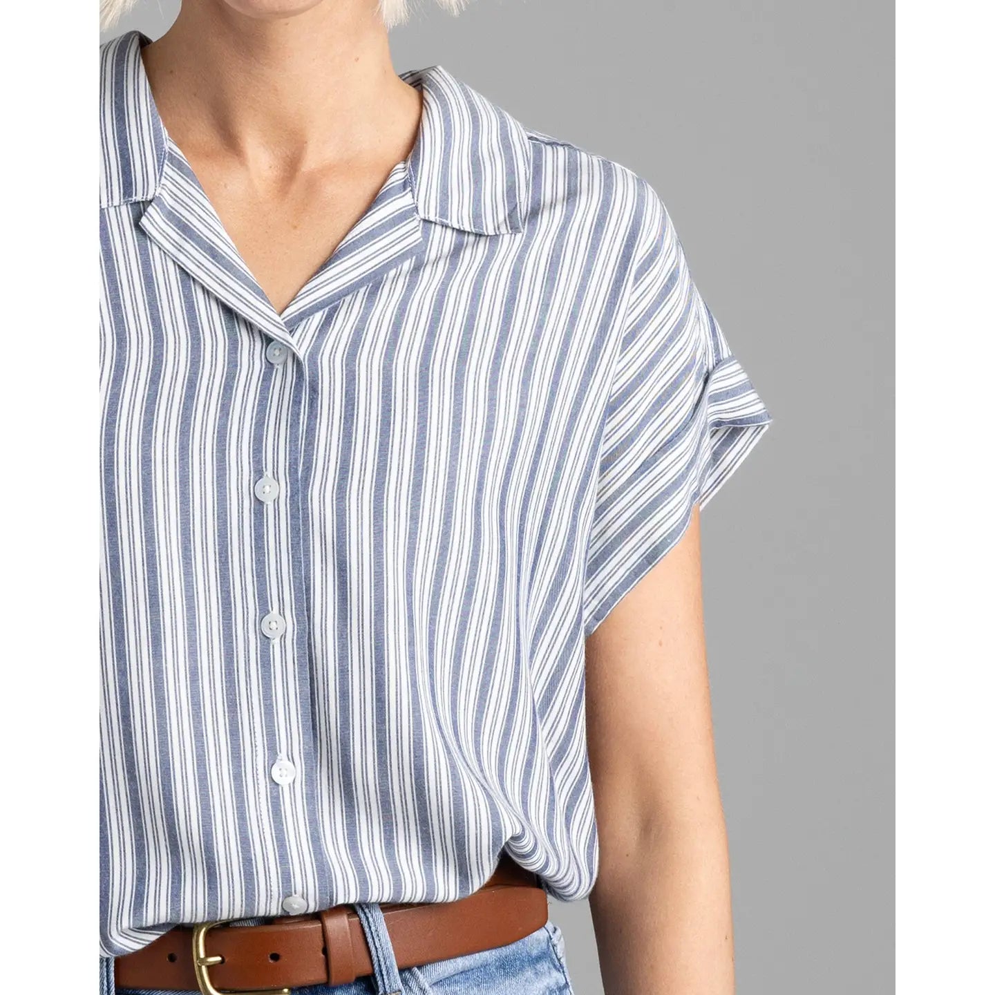 close up detail shot of willlow striped blouse with rolled short sleeve and jeans with a brown belt