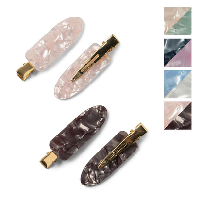 A set of four hair clips in two colors, with a marbled design and metallic gold clasps.