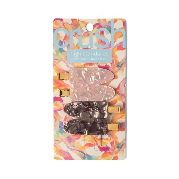 A set of four hair clips in two colors, gray and pink, with a marbled design and metallic gold clasps with packaging 