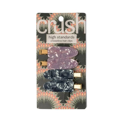 A set of four hair clips in two colors, gray and pink, with a marbled design and metallic gold clasps.