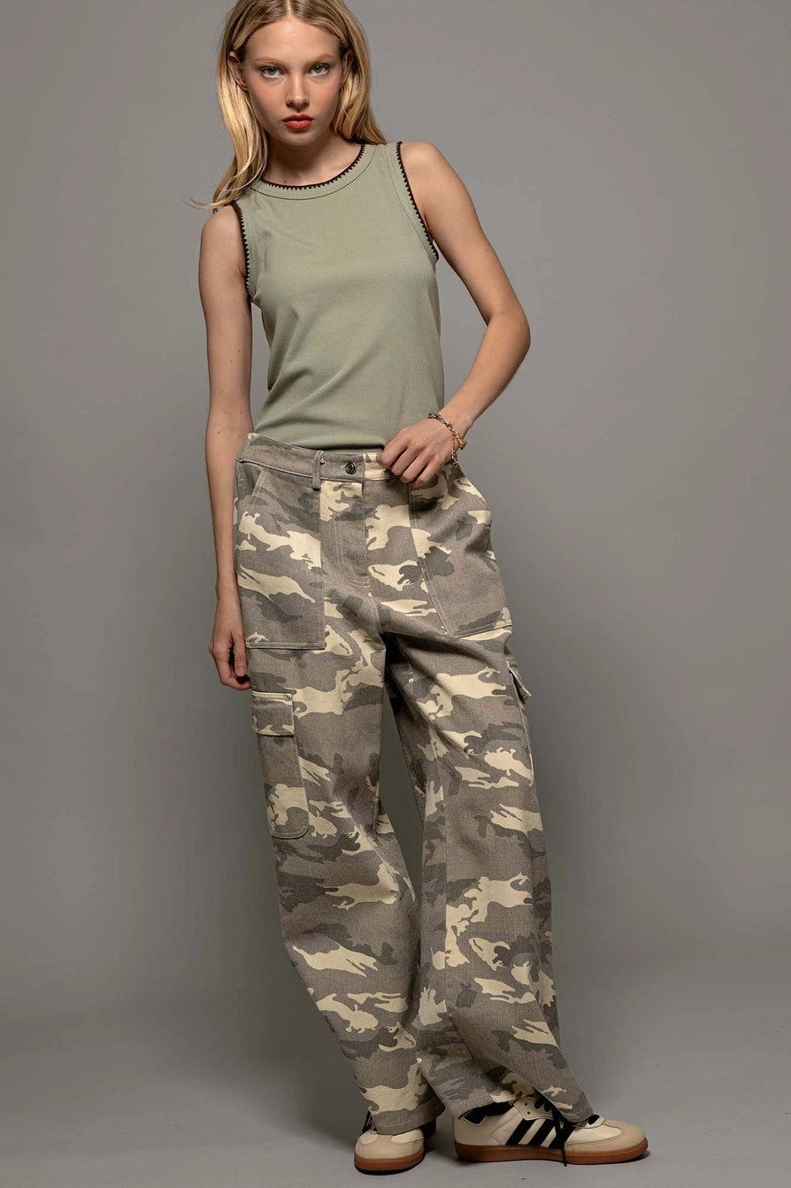 front view of model wearing green ribbed tank top with detail trim and loose camo pants with sneakers