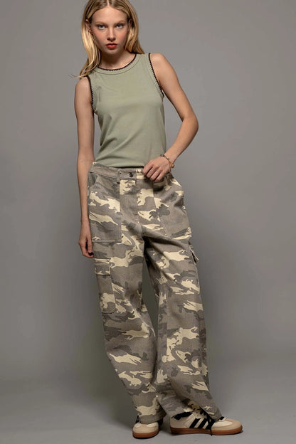 front view of model wearing green ribbed tank top with detail trim and loose camo pants with sneakers