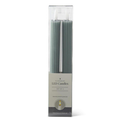 A set of two green LED taper candles in a clear plastic package with a paper label, shown against a plain white background.