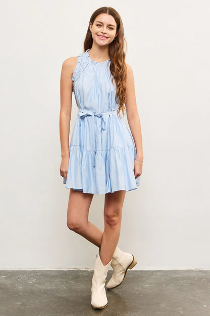 model wearing light blue ruffled midi dress with white boots