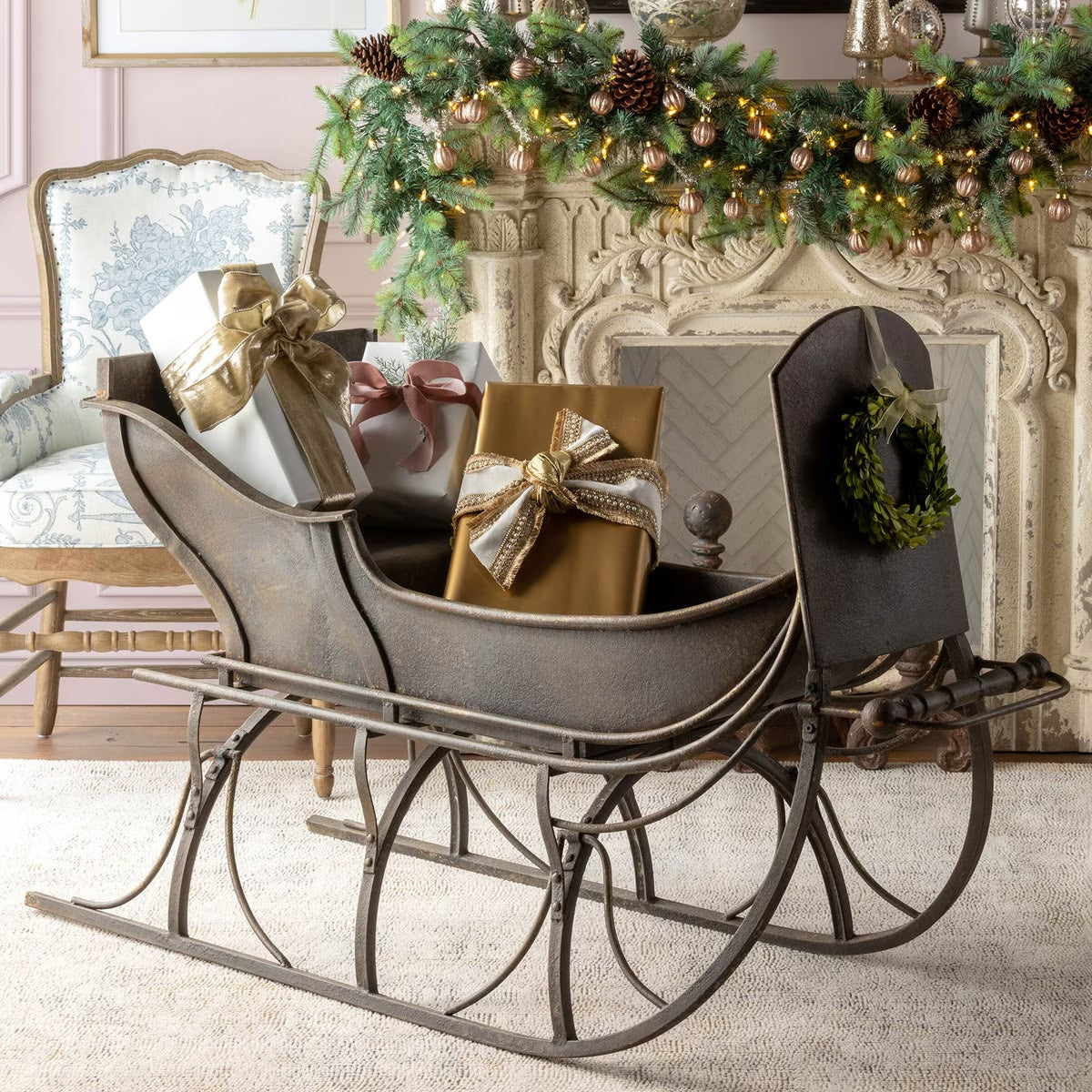 sleigh with gifts by fireplace holiday display