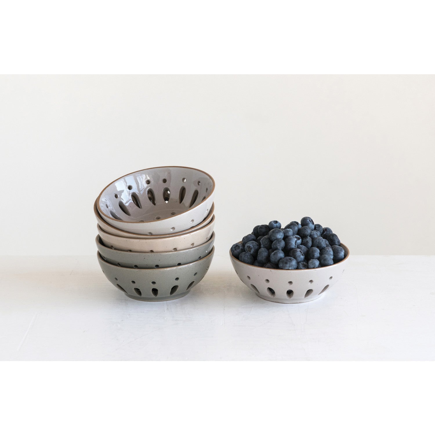 Set of ceramic bowls with blueberries on a white background