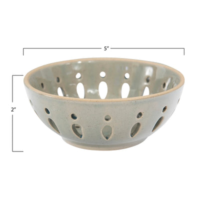 Gray ceramic bowl with perforated design on a white background