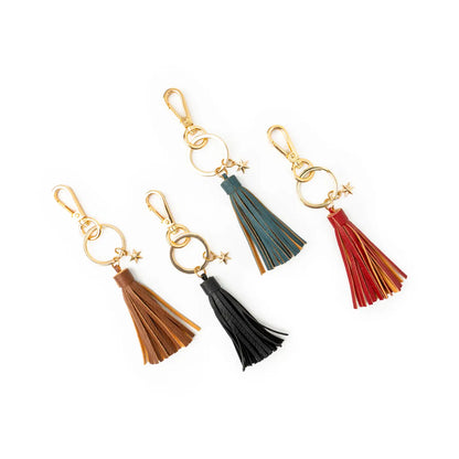 Four colorful tassel keychains on a white background