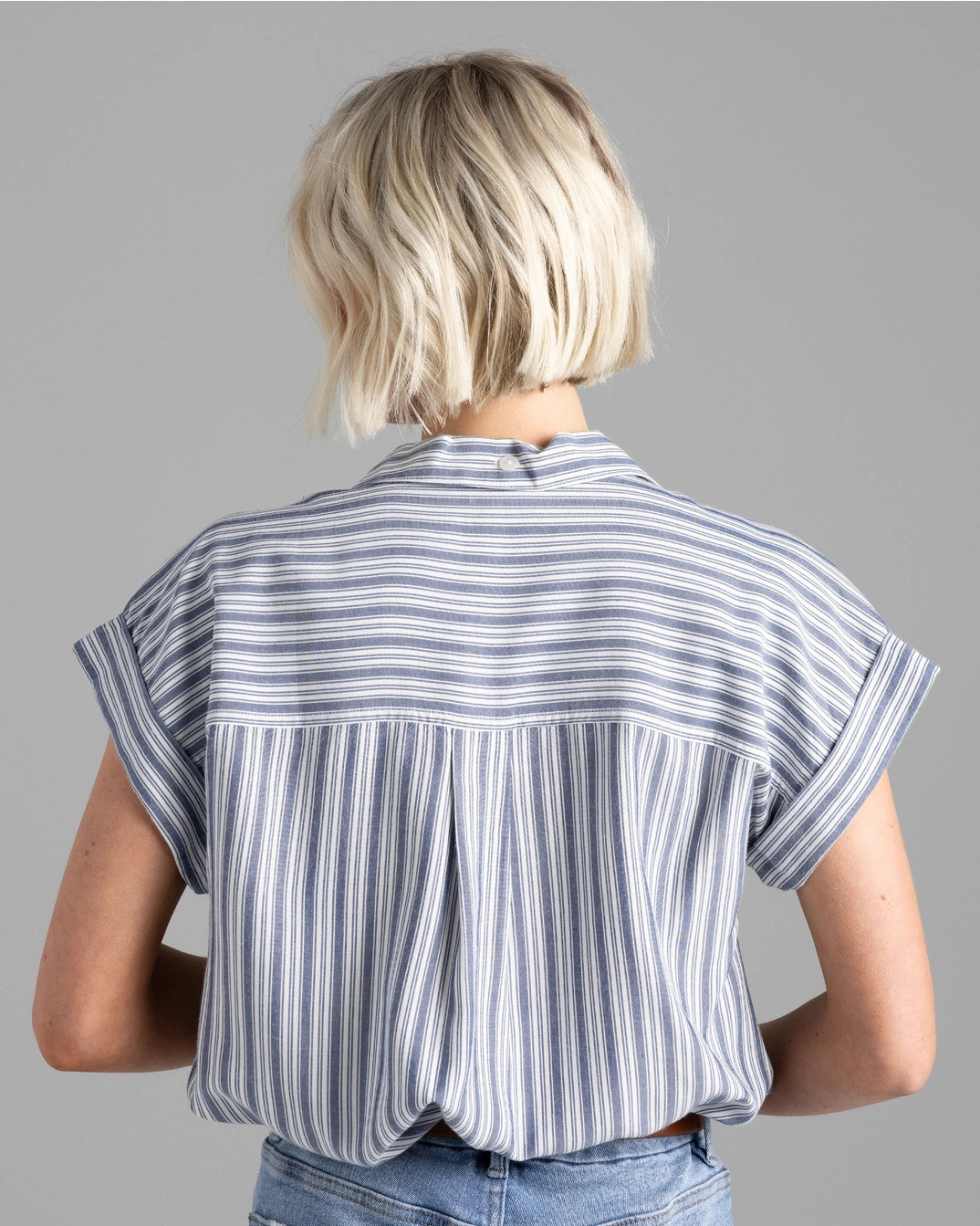 back view of short sleeve blouse with stripes and a rolled sleeve