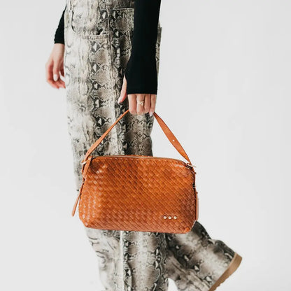 Woven shoulder bag in warm orange with adjustable strap and zip top